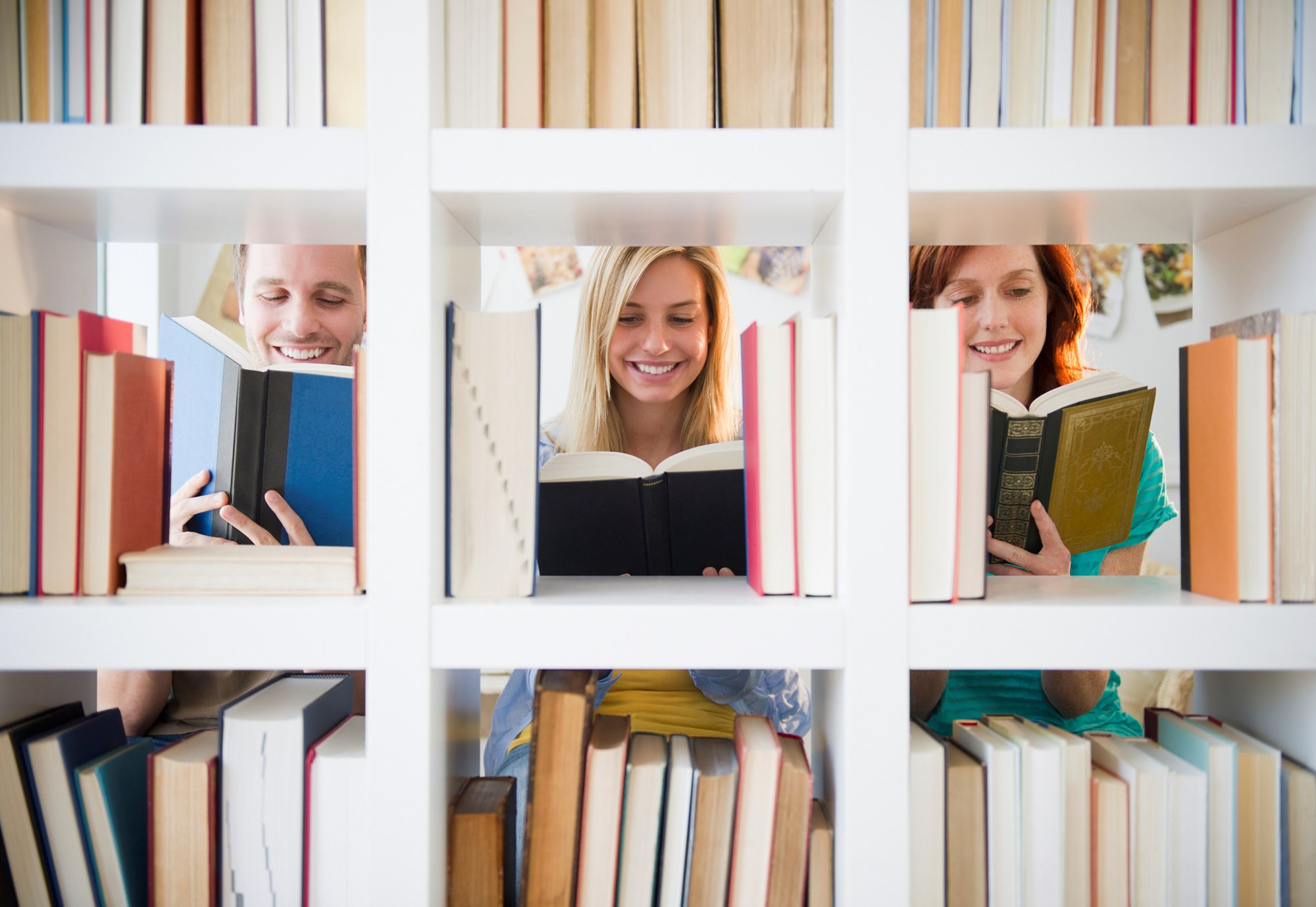 Group of Happy Students Reading Book in the Library