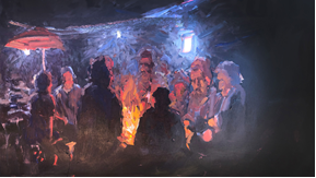Painting of men around a campfire. 