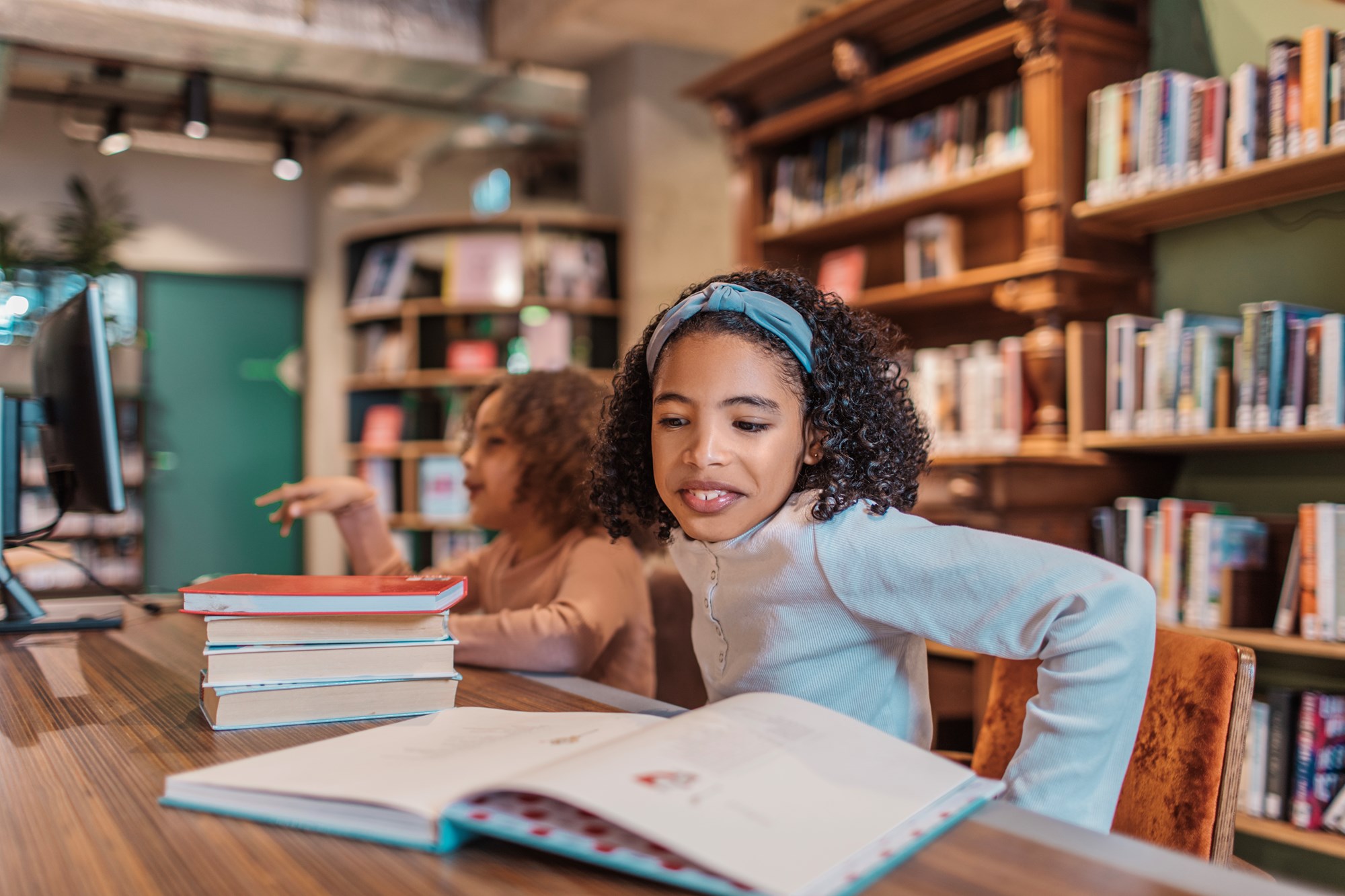 two girls in library reading