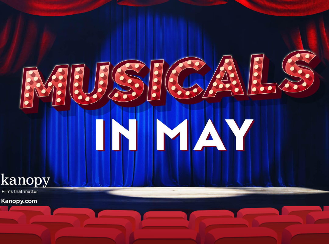 The text "Musicals in May" in bold, theatrical font is illuminated by spotlights on stage before rows of theater seating.