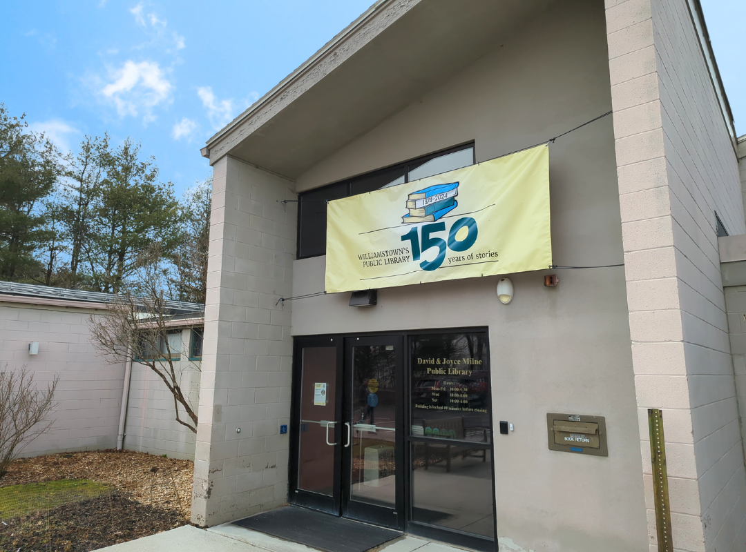 Photograph of library entrance, prominently featuring the library's 150th anniversary banner. 