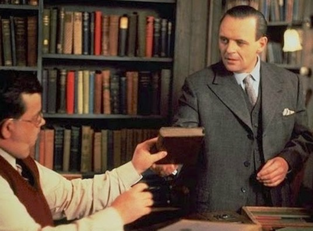 A screenshot from the Movie 84 Charing Cross showing a man handing a book to another
