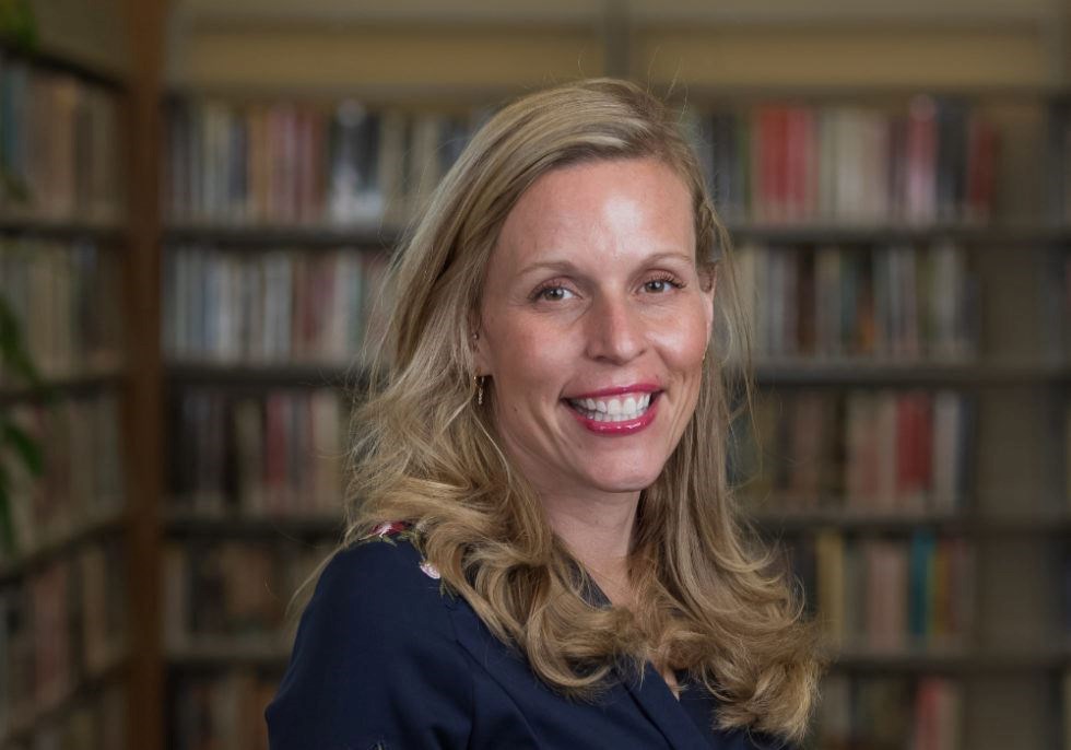 Photograph of library director, Angela Zimmermann, with bookcases in the background.