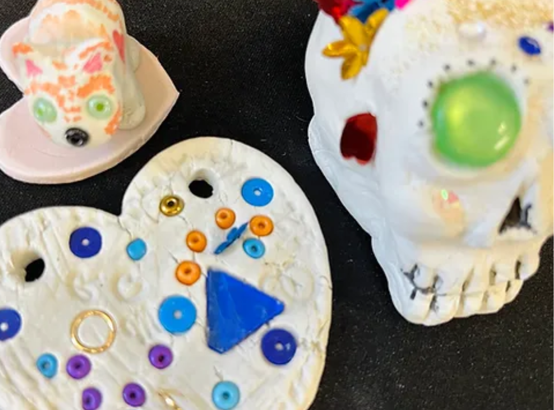 clay pieces (heart, skull, animal) decorated with colourful beads and shapes