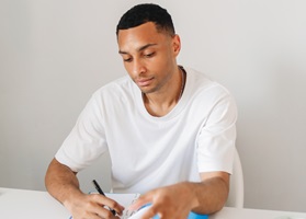Teen boy at a desk writing