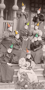 Vintage photo of Everett women's club members seated on porch stairs wearing added colorful party hats