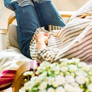Image depicts a women relaxing on a cozy chair.