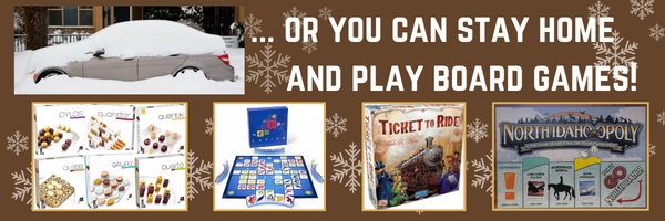 small image shows car buried in snow followed by ellipses or you can stay home and play board games!  A dark brown background with snowflakes in the background.  There are four board games forming the bottom border: a small wooden one (name unknown), a blue one (name also unknown), ticket to ride, and north idaho-opoly.