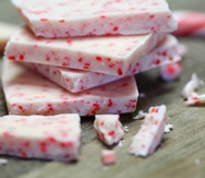 Small stack of square white chocolate with red flakes of peppermint. The event this image is linked to is an external site and will open in a new tab or window.